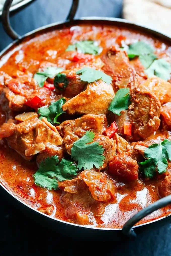 Closeup picture of Slow-Cooked Spicy Chicken Curry in a serving bowl on a dark background