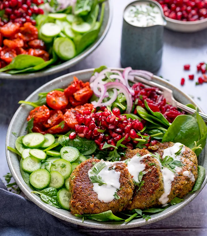 https://www.kitchensanctuary.com/wp-content/uploads/2019/08/Falafel-salad-bowl-with-pomegranate-and-feta-dressing-tall-FS.webp