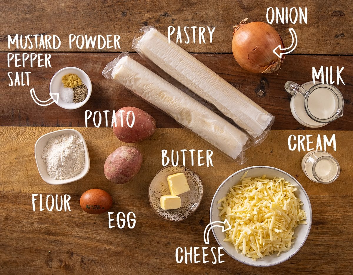 Ingredients for individual cheese and onion pies on a wooden table